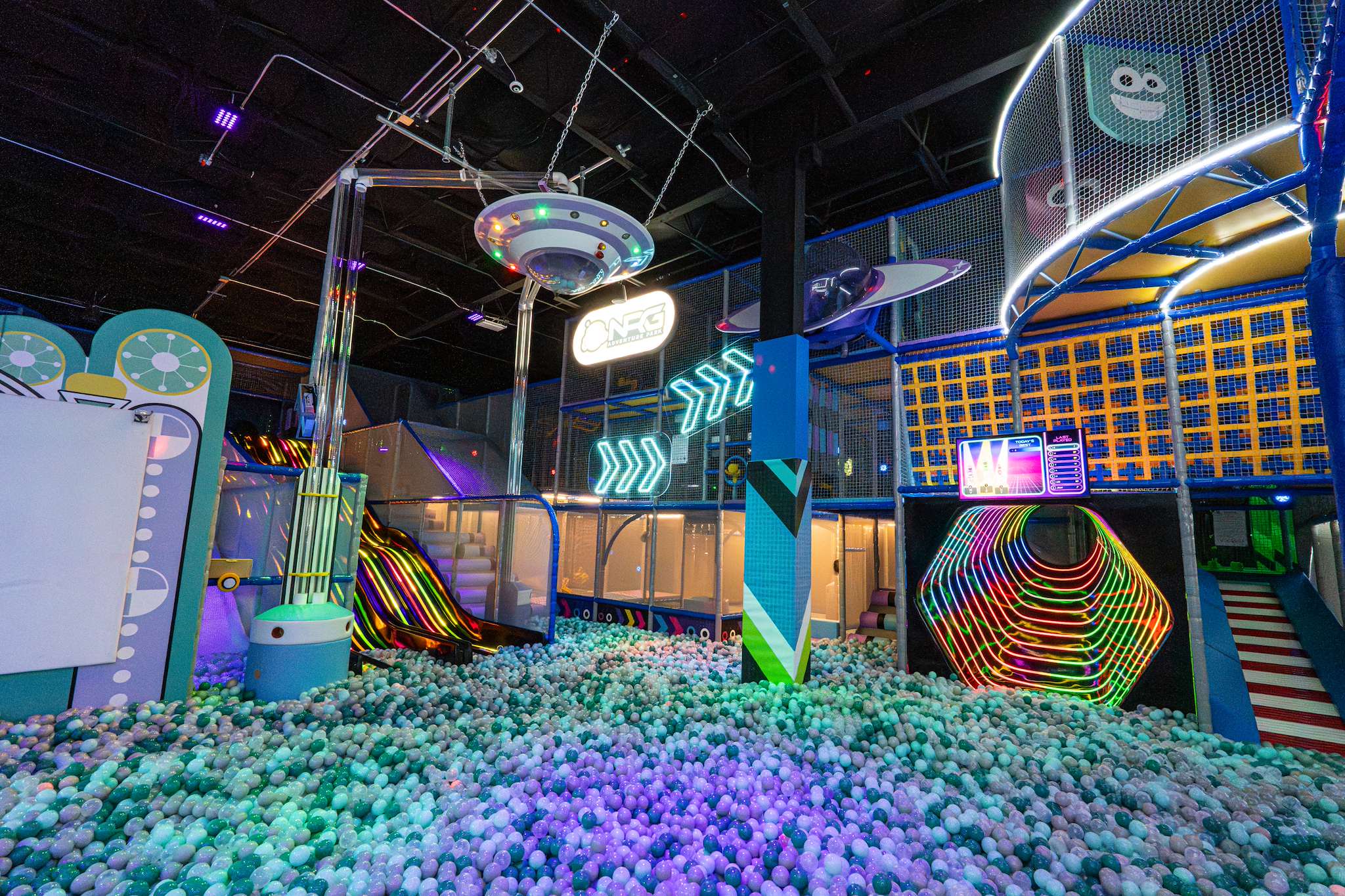 Soft play ball pit with a neon tunnel and slides at NRG Fargo